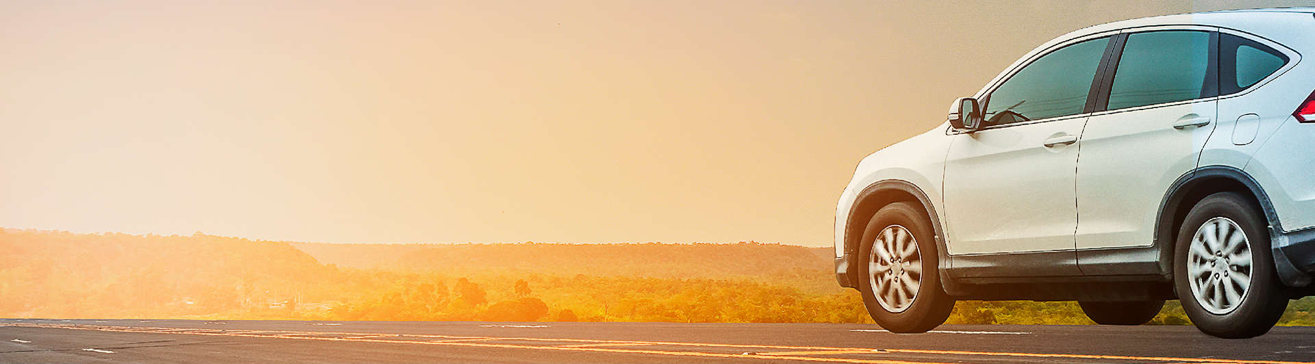 Vista de un vehículo blanco y una puesta de sol  